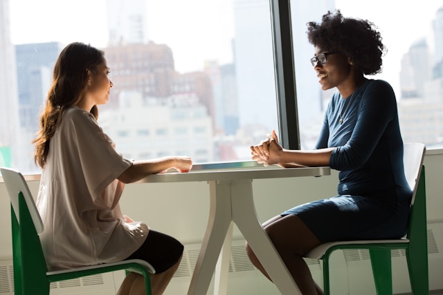 two business professionals sitting down, meeting in person